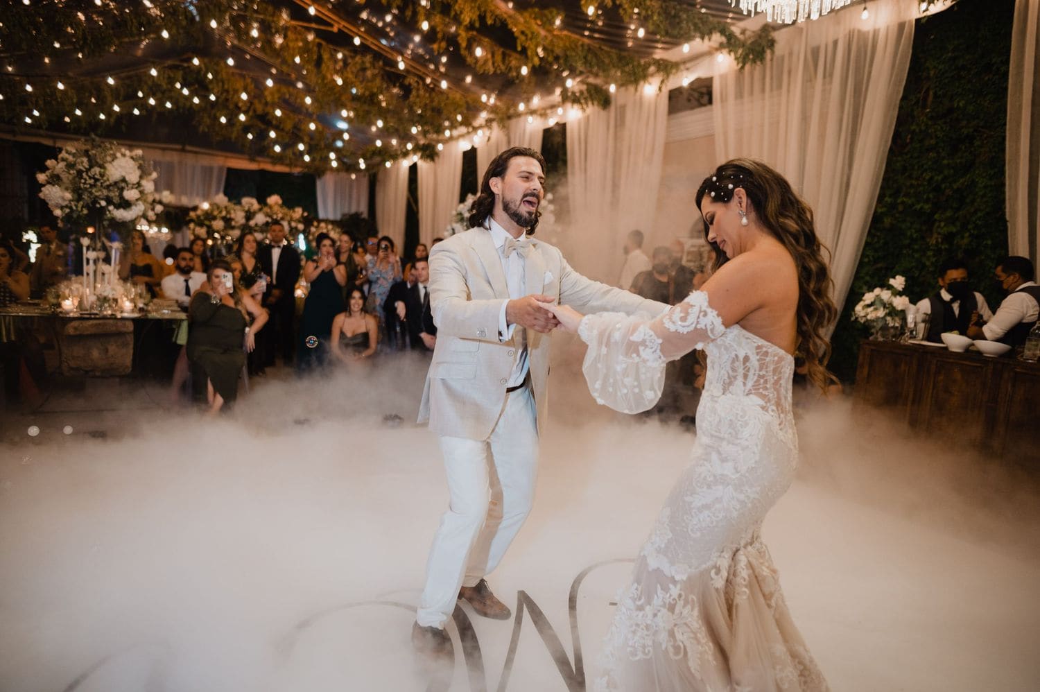Groom sings to the bride as they spin through low fog on the reception dance floor at Hotel Pensativo.
