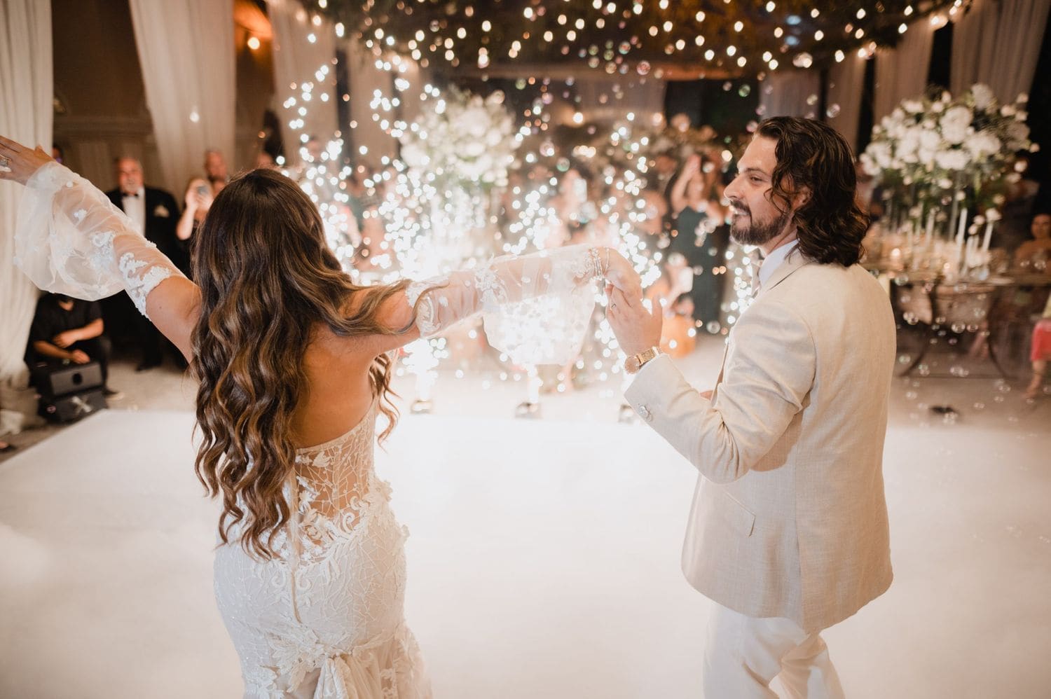 Bride and groom face off dancing as bright sparkler fountains shoot up behind them inside the Hotel Pensativo tent.