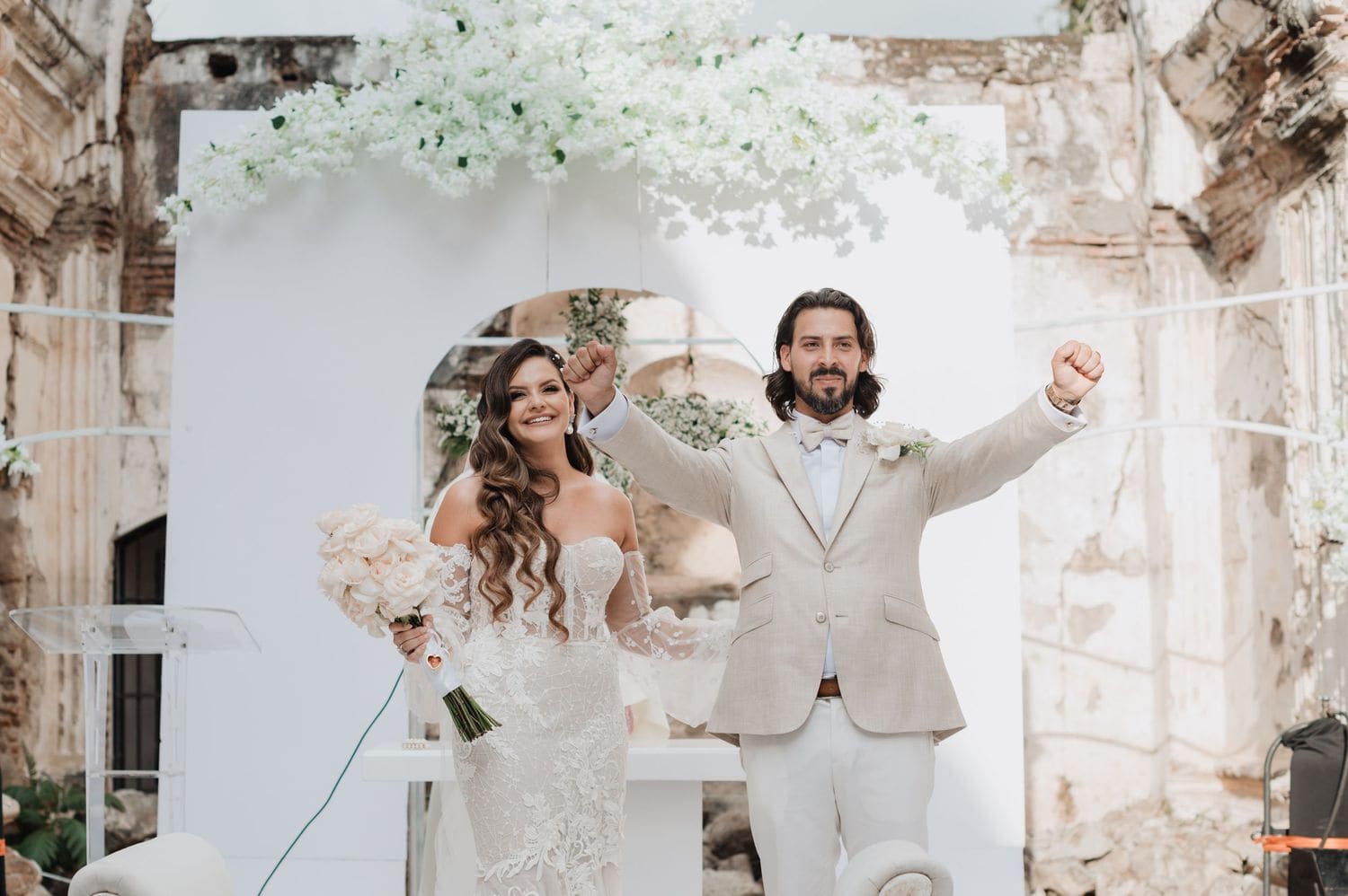 Newlyweds raise their fists in celebration at the altar after being pronounced husband and wife at Casa de la Ruina.