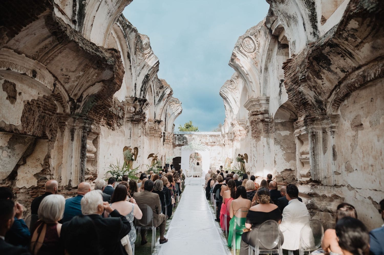 Guests gather between massive ruined columns watching the ceremony unfold at Casa de la Ruina, Antigua Guatemala.