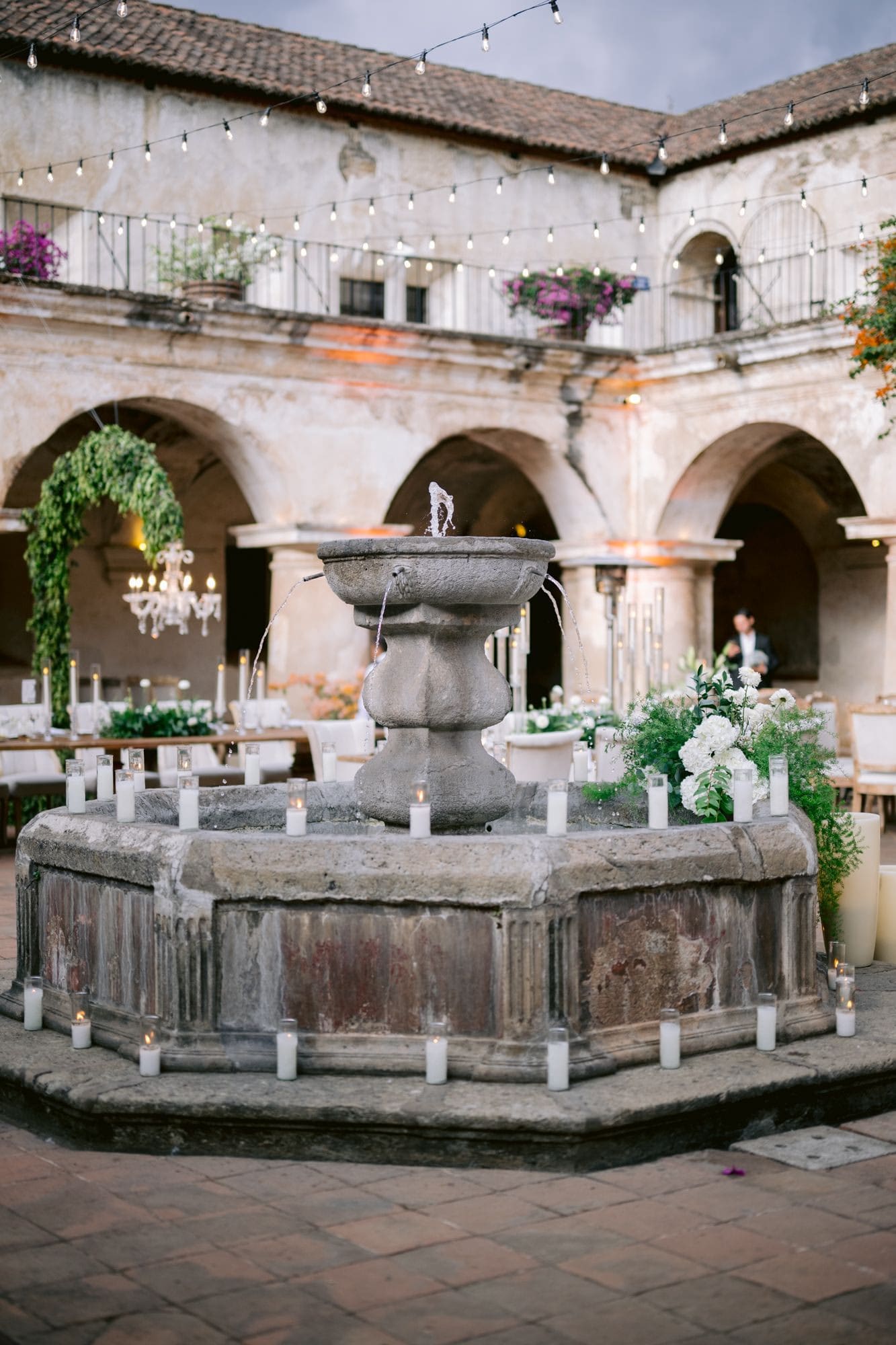Historic stone fountain courtyard with floral arrangement