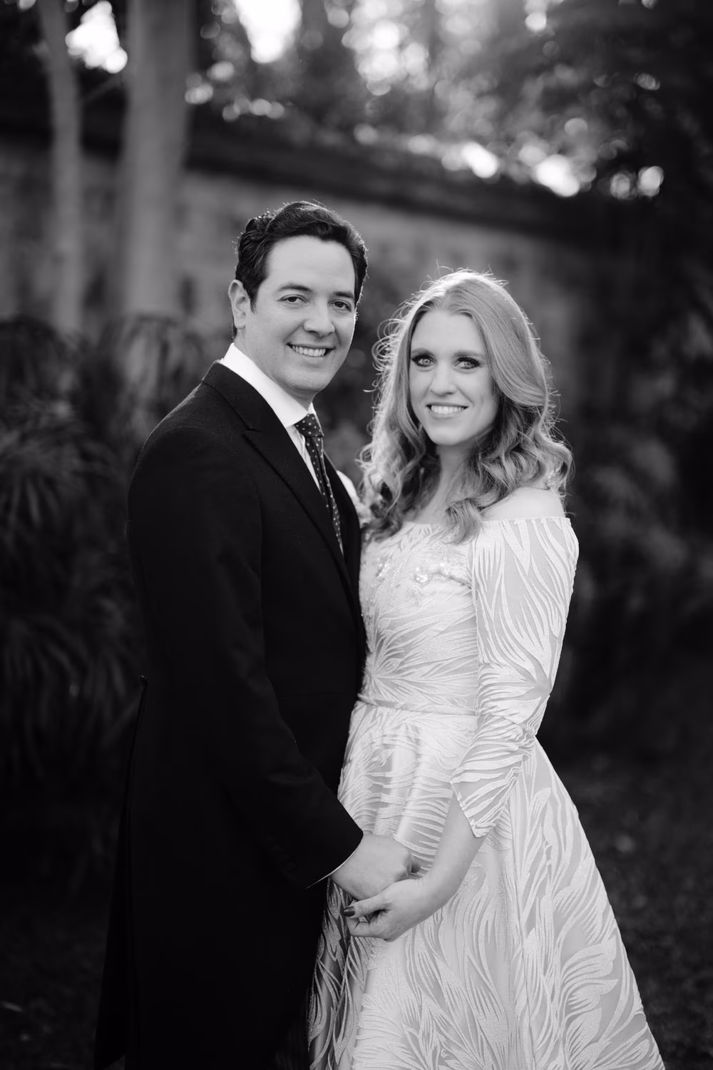 Bride and groom pose hand-in-hand for a classic black-and-white portrait in the garden before their wedding in Antigua.