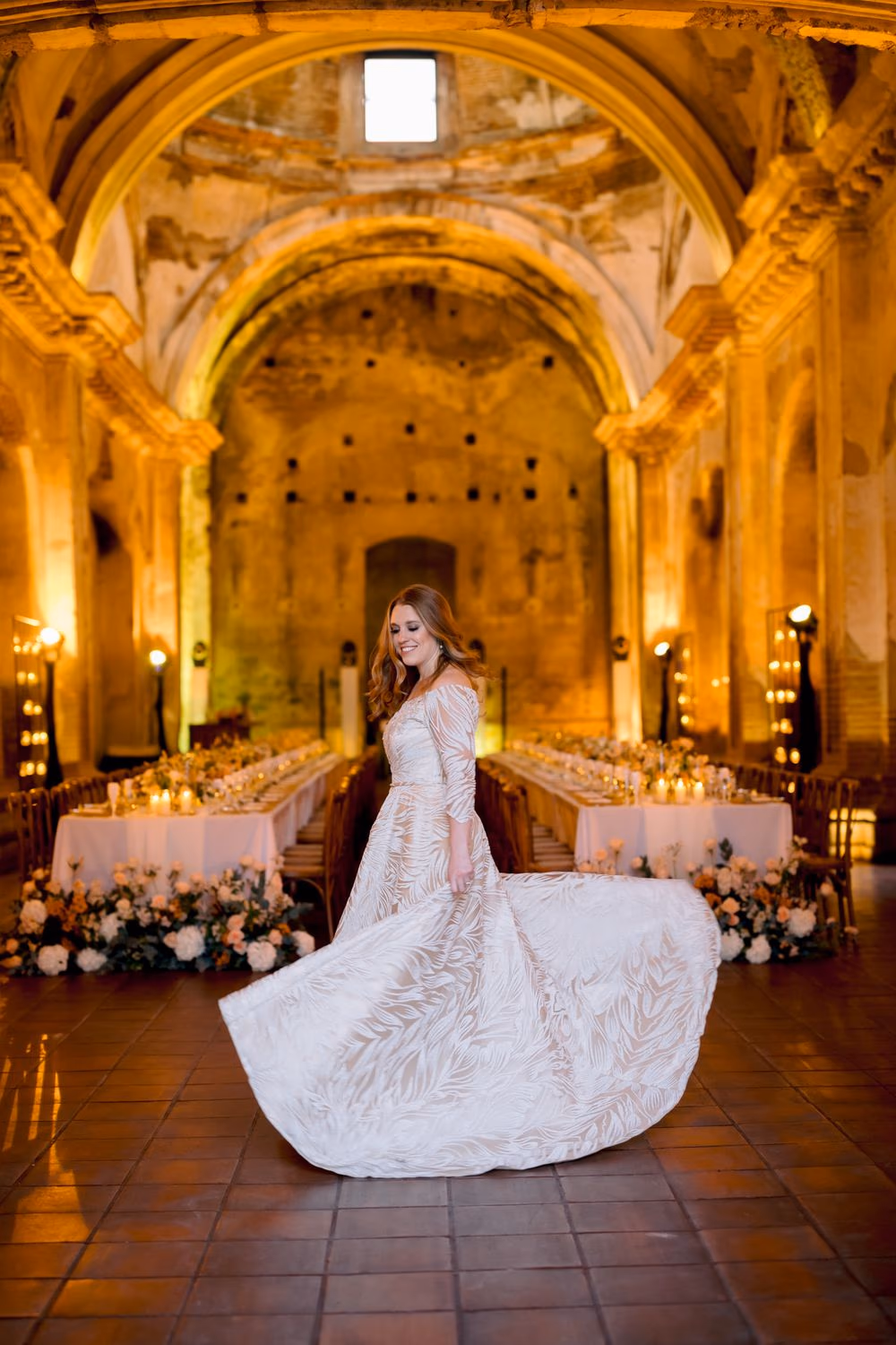 Bride twirls in the center aisle of San José el Viejo Ruins, gown unfurling under the cathedral arches — editorial bridal portrait.