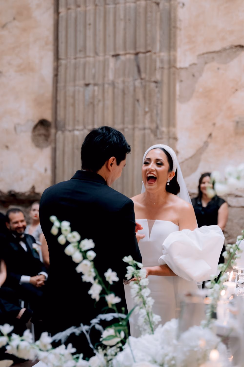 Bride laughs joyfully as she exchanges vows with the groom during the ceremony in Antigua Guatemala.
