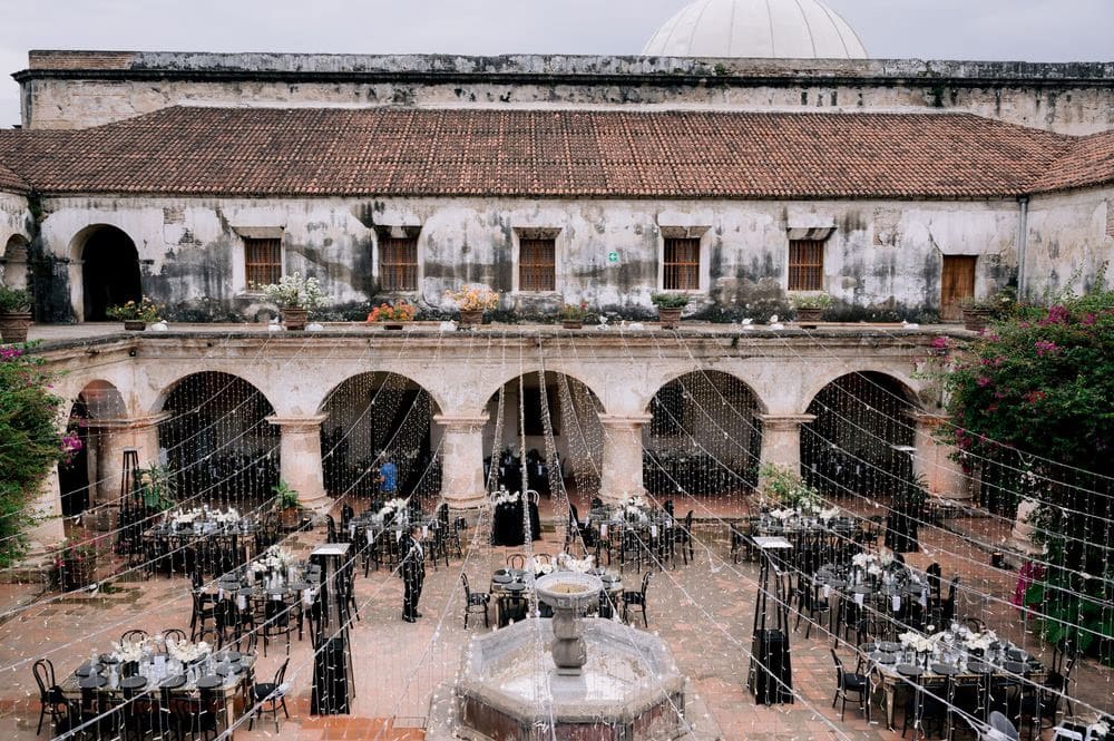 Aerial view of the reception courtyard at Capuchinas with arches, fountain and string-light canopy being set up.