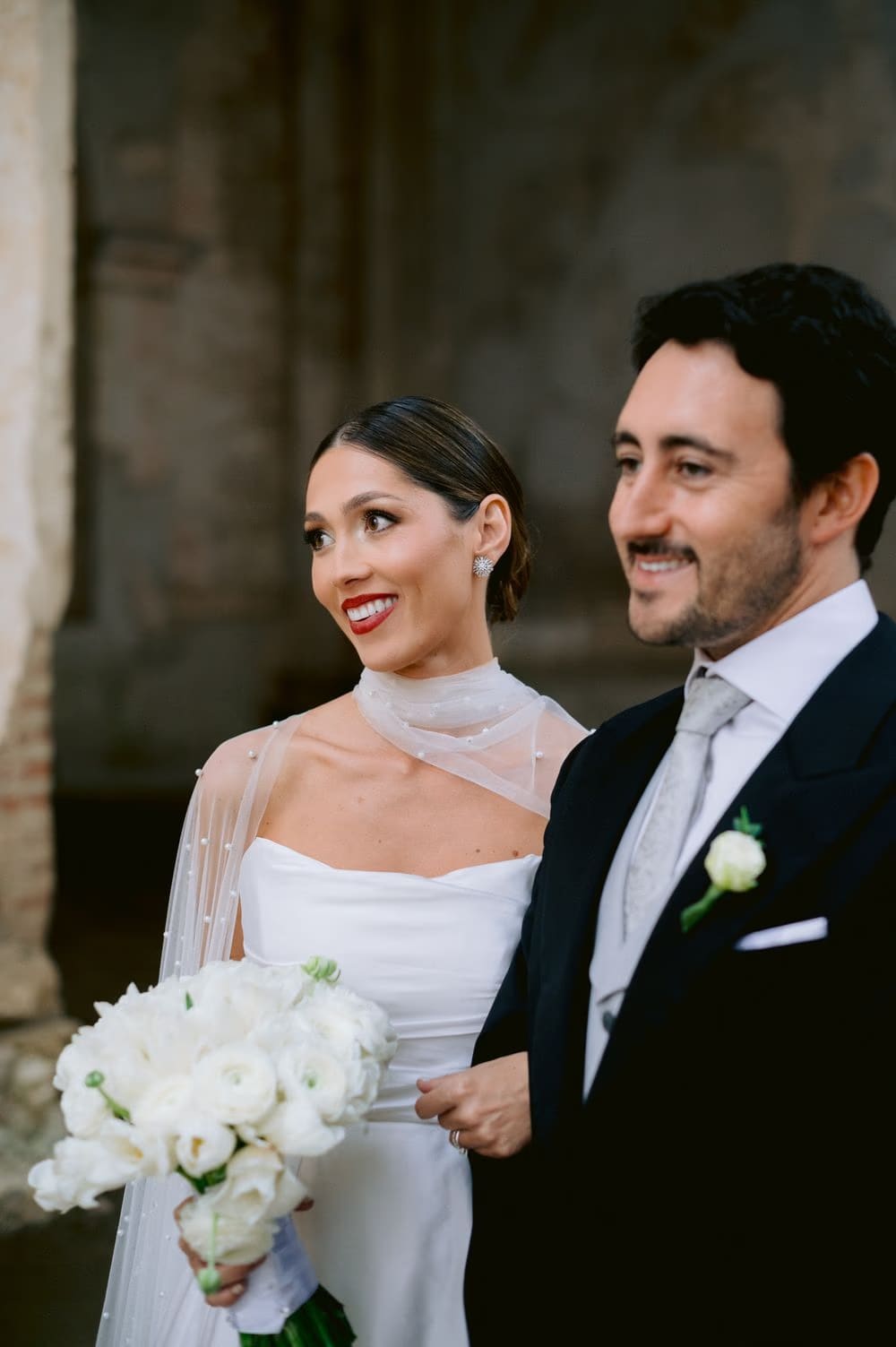 Bride and groom share a quiet smile arm-in-arm in the cloister — destination wedding portrait in Antigua Guatemala.
