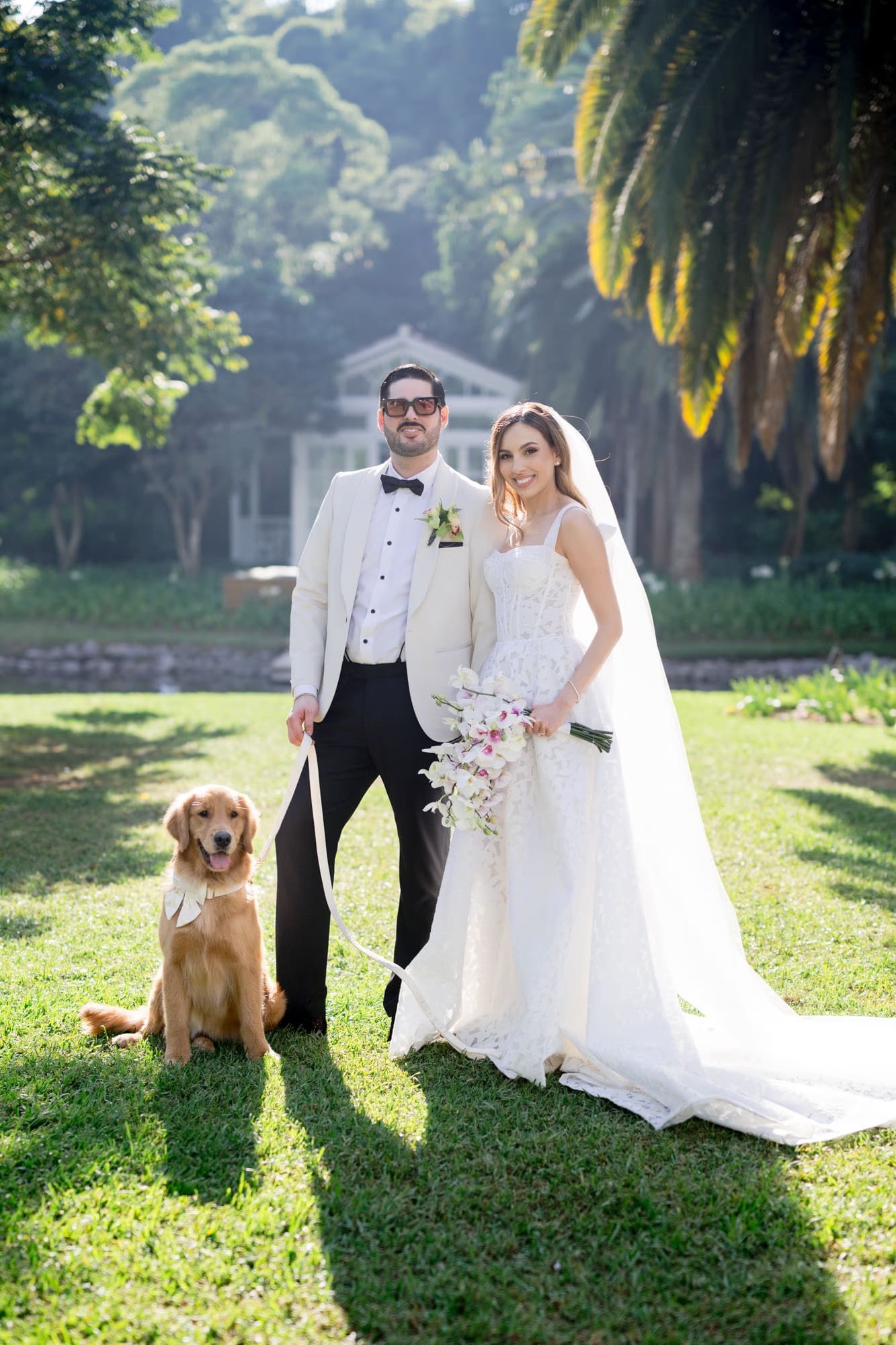 Caro and Sergio pose with their golden retriever Nala in the tropical gardens of Villa Bokeh, Antigua Guatemala.