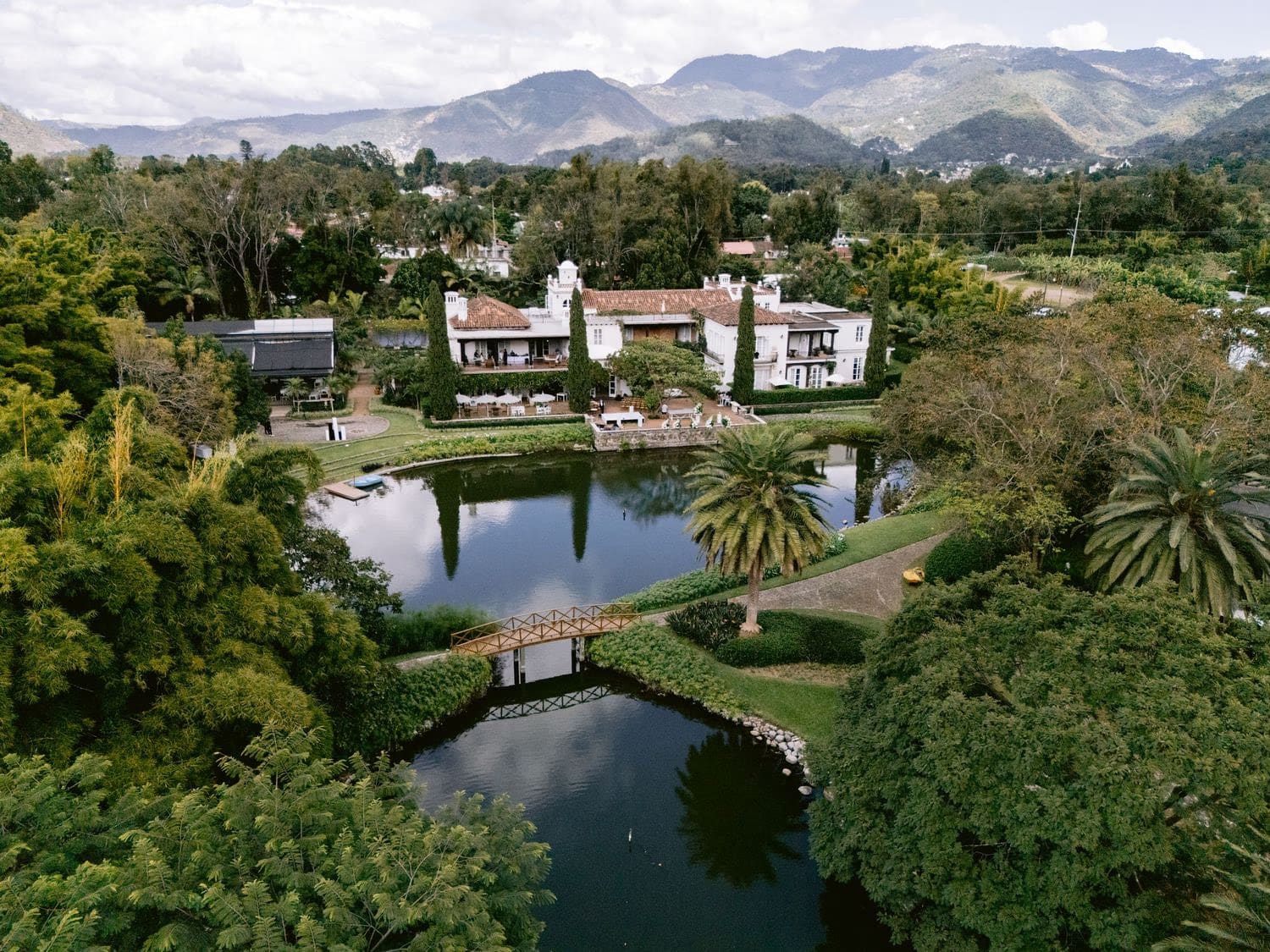 Aerial view of Villa Bokeh estate, ponds and gardens beneath the volcanoes of Antigua Guatemala.