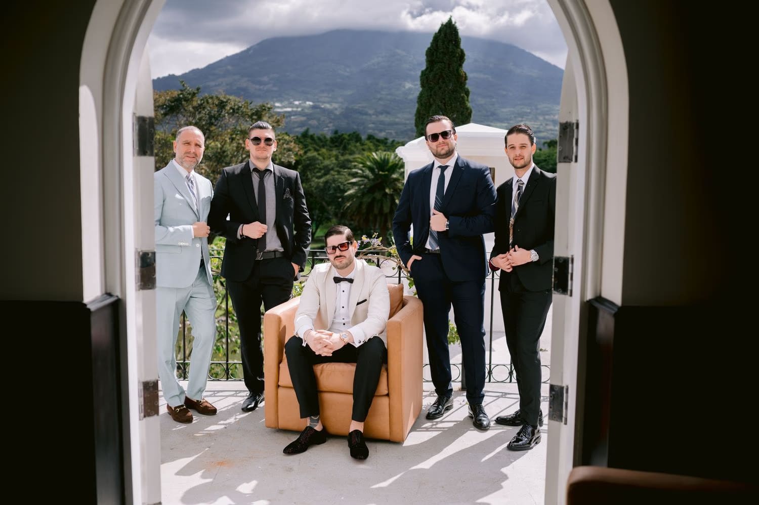 Groom and his groomsmen pose on an arched terrace at Villa Bokeh before the ceremony.