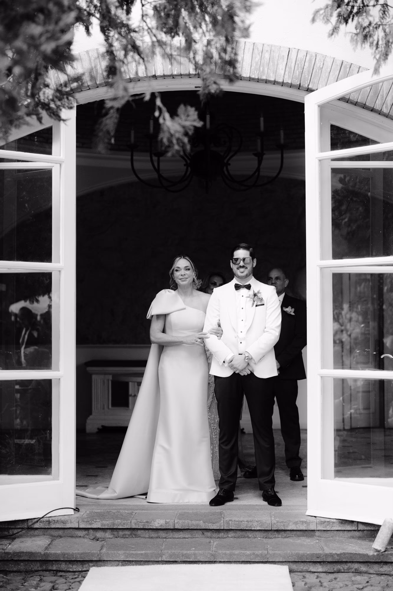 Bride and groom framed by an arched doorway just before the ceremony, in black-and-white — editorial Antigua Guatemala wedding.