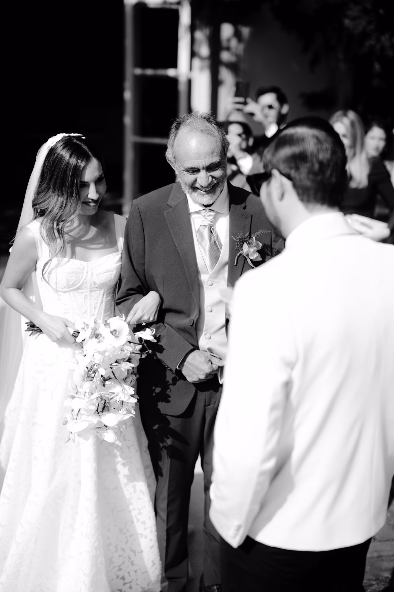 Father of the bride beams as he hands his daughter to the groom — black-and-white aisle moment in Antigua Guatemala.