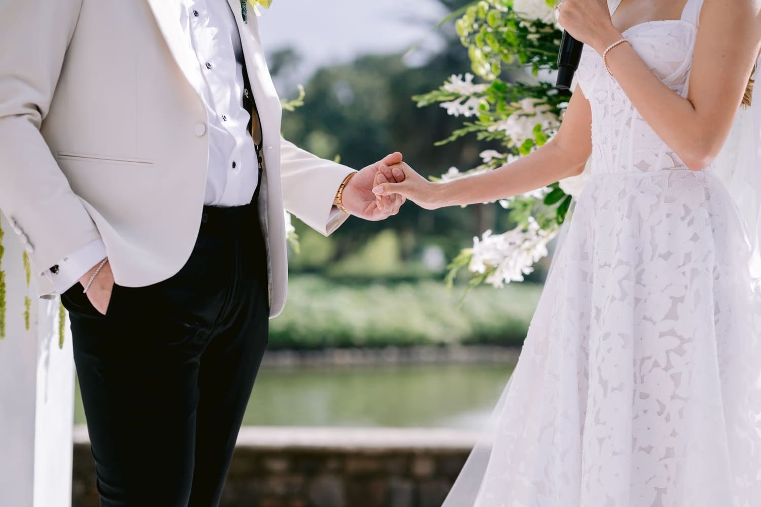 Close-up of bride and groom's hands meeting during vows — wedding detail at Villa Bokeh.