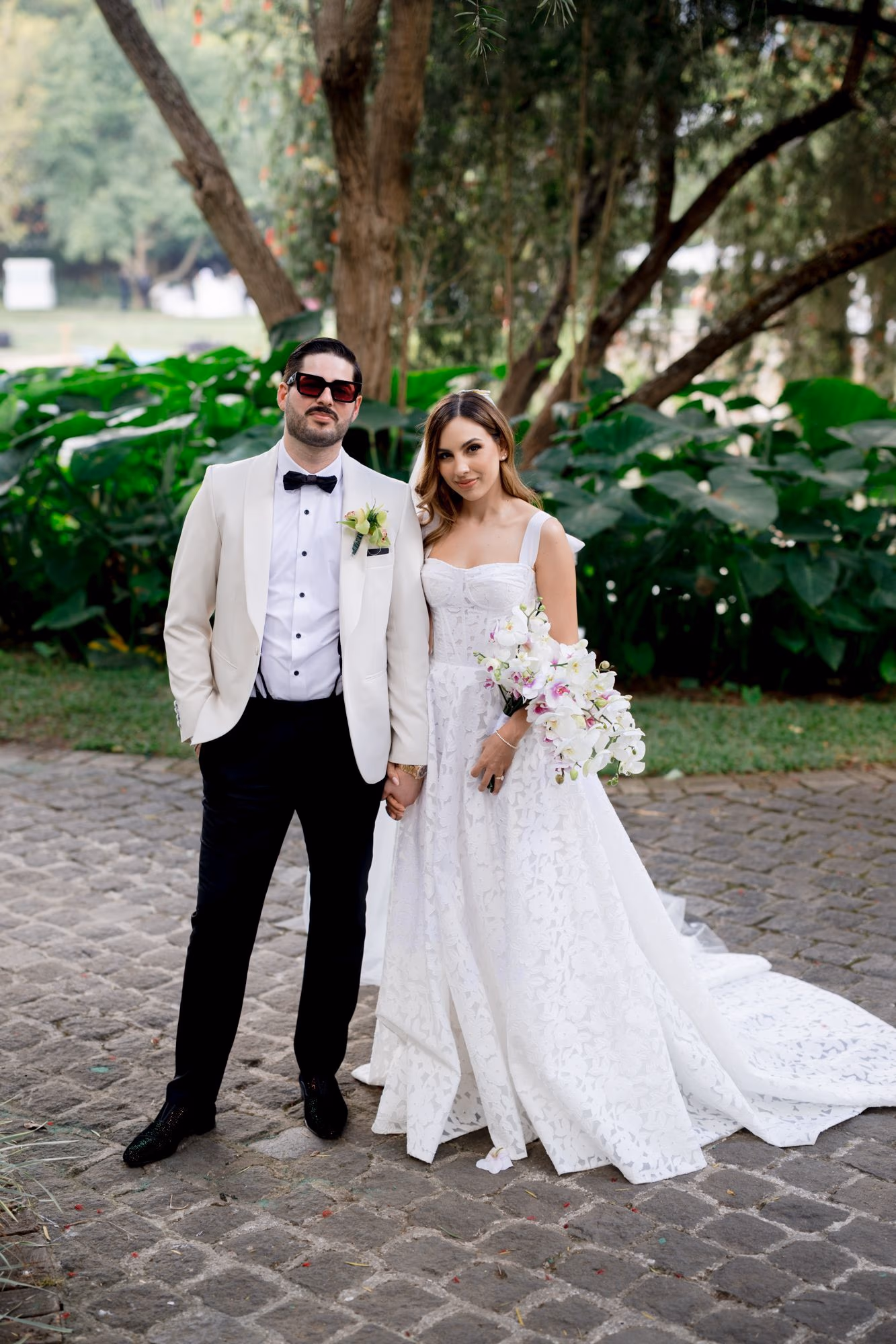 Couple portrait beneath a flowering tree in the tropical gardens of Villa Bokeh.