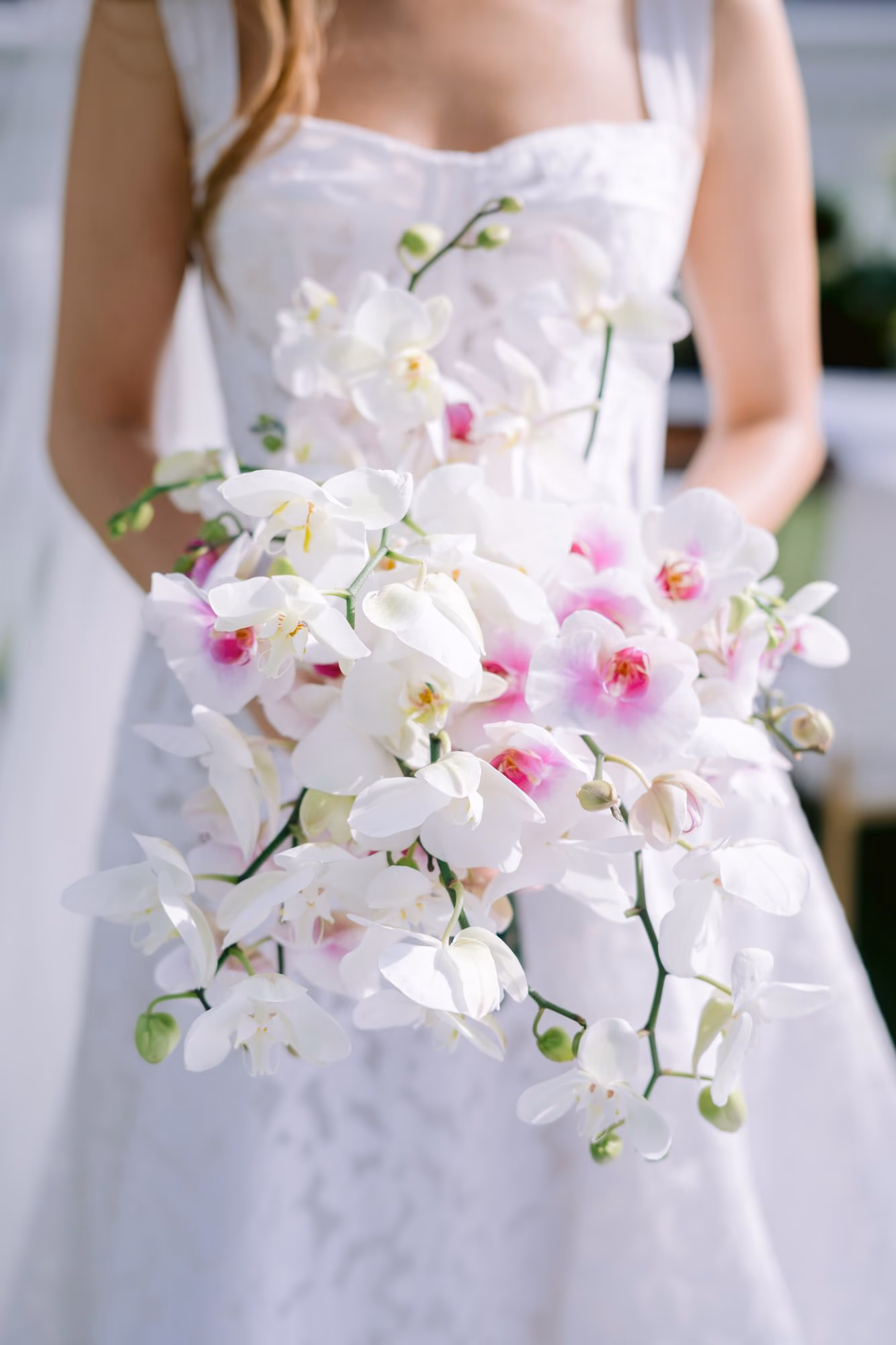 Close-up of the bride's cascading bouquet of white and magenta phalaenopsis orchids — wedding flowers in Antigua Guatemala.
