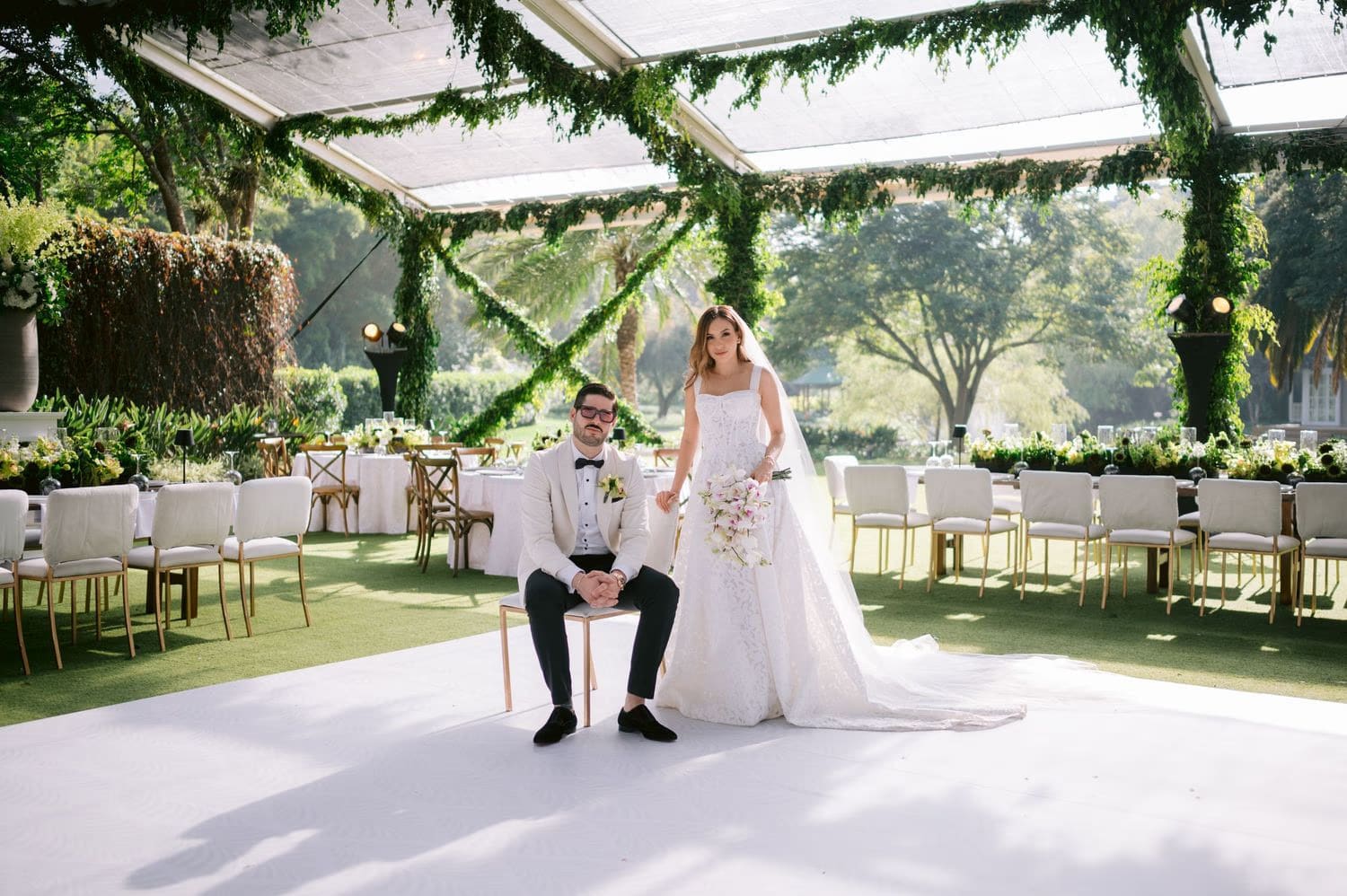 Wide view of bride and groom inside the empty greenery-draped reception tent — destination wedding in Antigua.