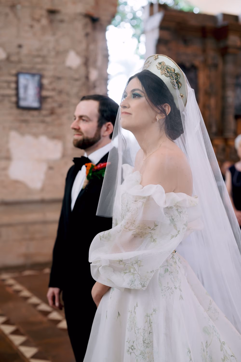 Bride and groom stand side by side at the altar of the candle-lit chapel inside Casa Santo Domingo — ceremony moment.