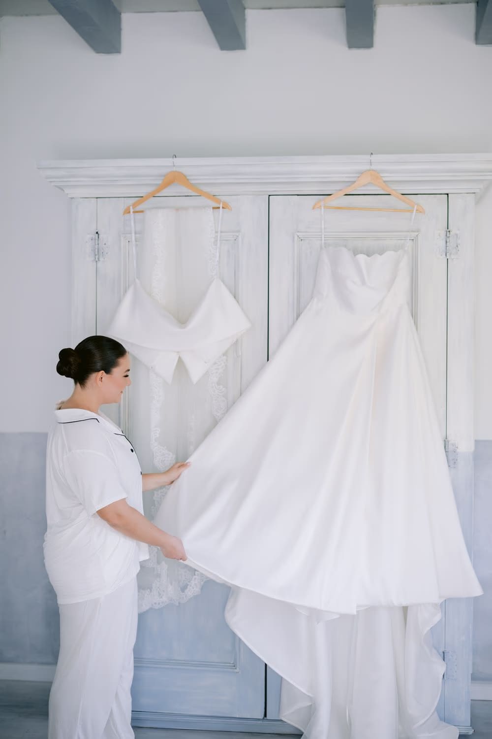 The bride gently lifts the train of her dress before getting ready — modern wedding morning in Antigua Guatemala.