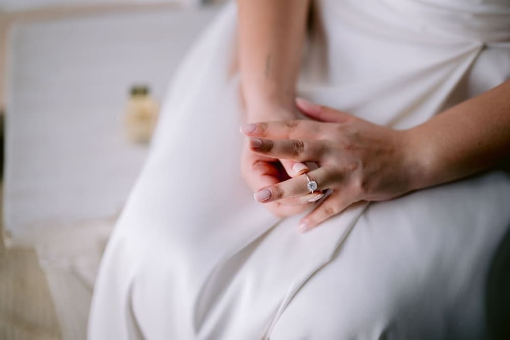 Close-up of the bride's hands resting on her gown showing her engagement diamond — wedding detail in Antigua Guatemala.