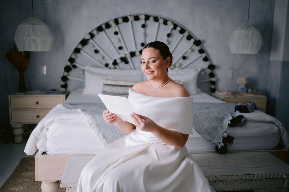 Johanna reads a handwritten note from her groom before the ceremony — quiet getting-ready moment.