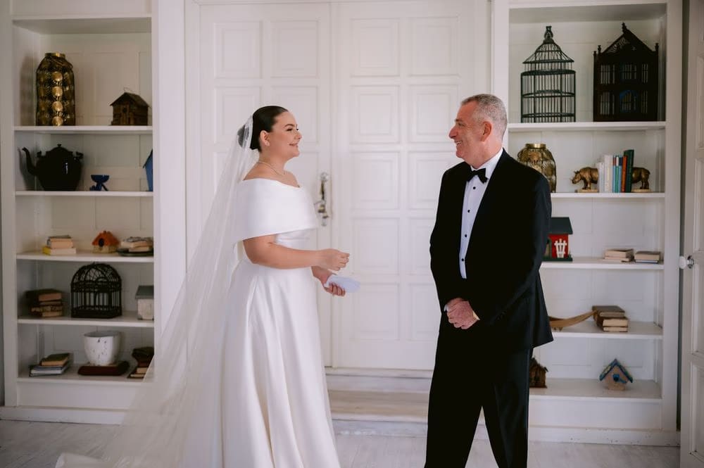 The father of the bride smiles as he sees his daughter for the first look — emotional pre-ceremony moment.