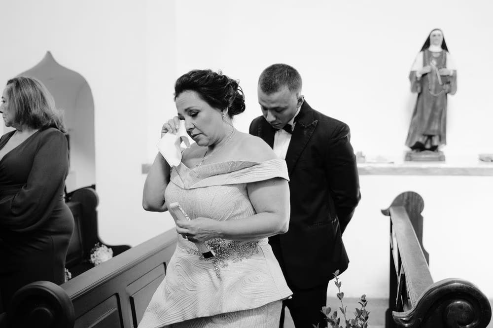 Mother of the bride wipes a tear during the wedding ceremony — black-and-white candid in Antigua Guatemala.