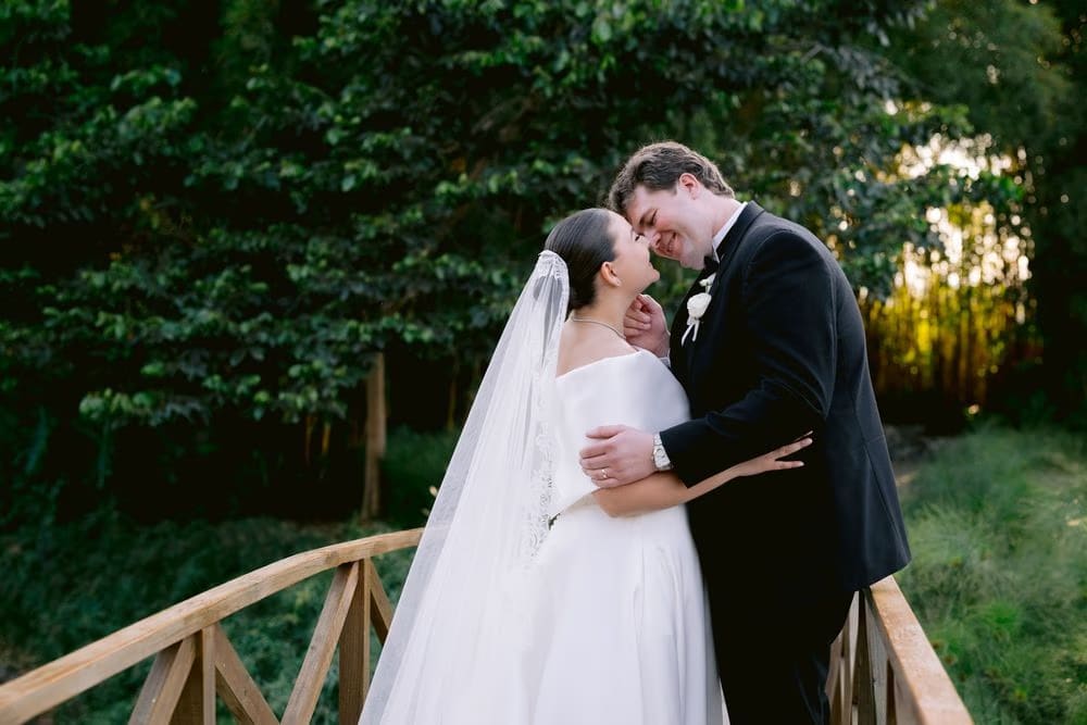 Forehead-to-forehead moment on the wooden bridge at sunset — wedding portrait at Villa Bokeh.