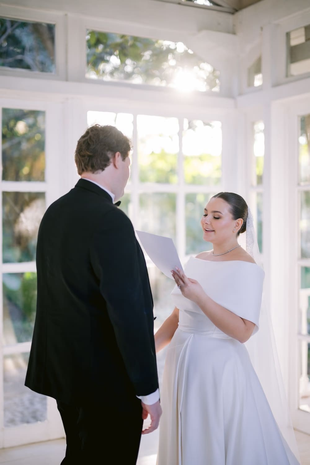 The bride reads her vows aloud to the groom inside the gazebo at Villa Bokeh.