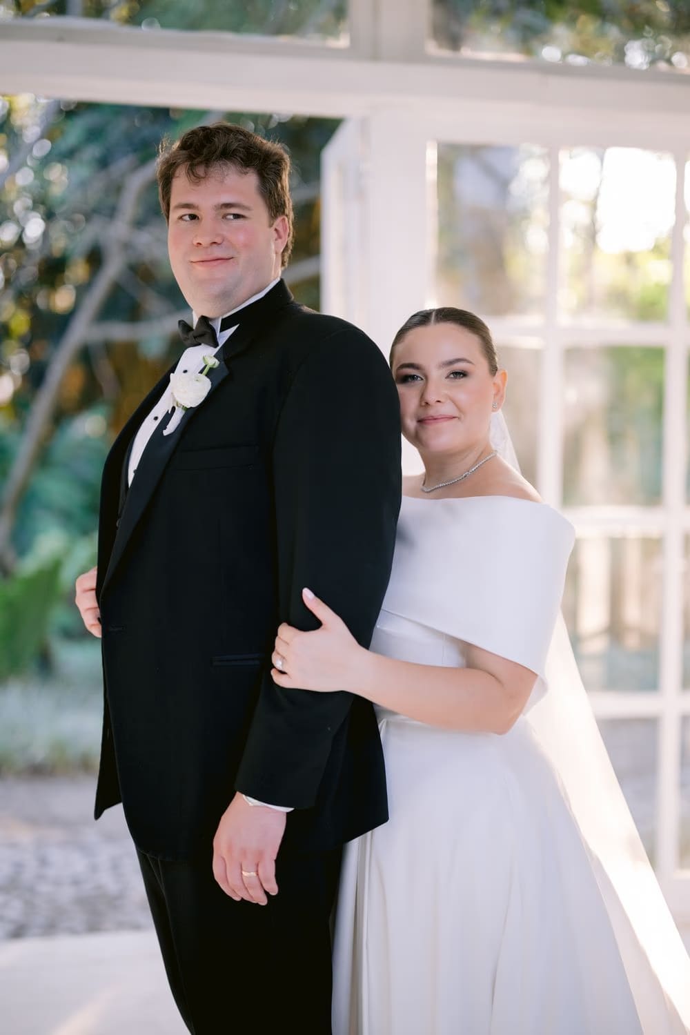 Editorial portrait of the bride and groom inside the bright glass gazebo at Villa Bokeh.