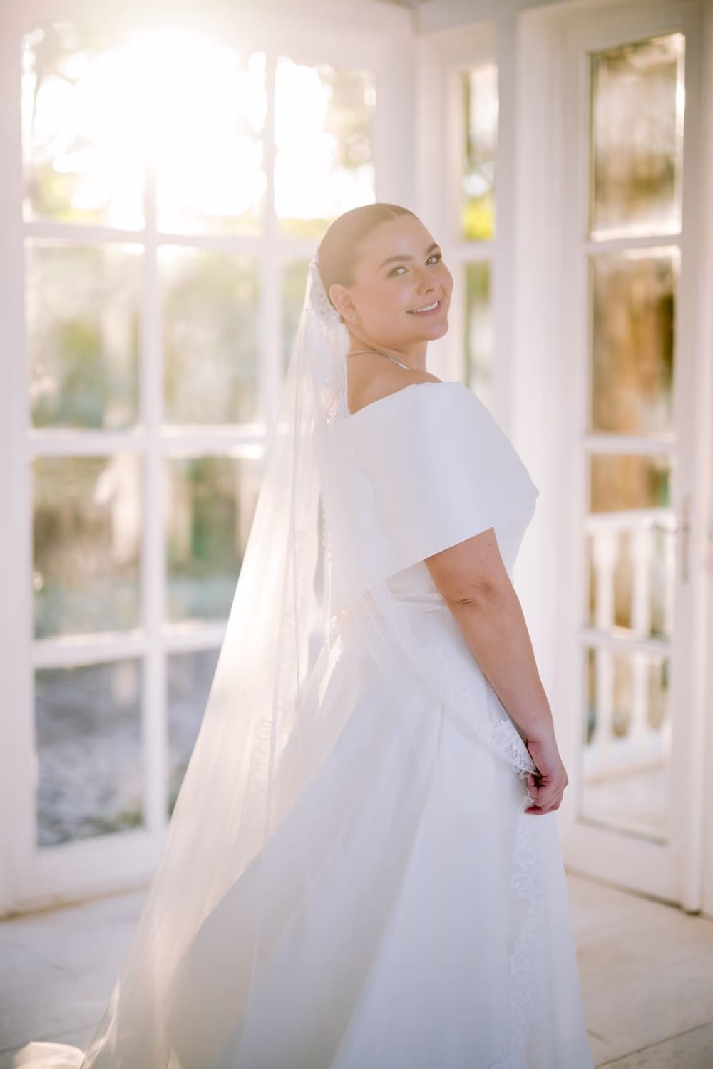 Backlit bridal portrait at the gazebo with the cathedral veil catching the late afternoon sun.