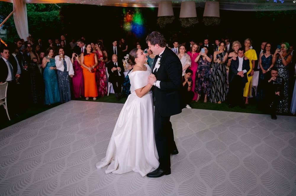 Bride and groom share their first dance surrounded by guests in evening attire — Villa Bokeh reception.