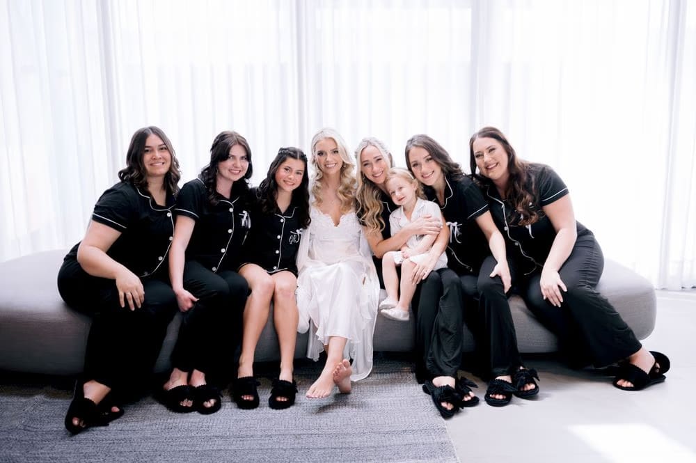 Bride surrounded by bridesmaids in matching black pajamas during getting-ready morning at Casa Kuxtal, La Antigua Guatemala.