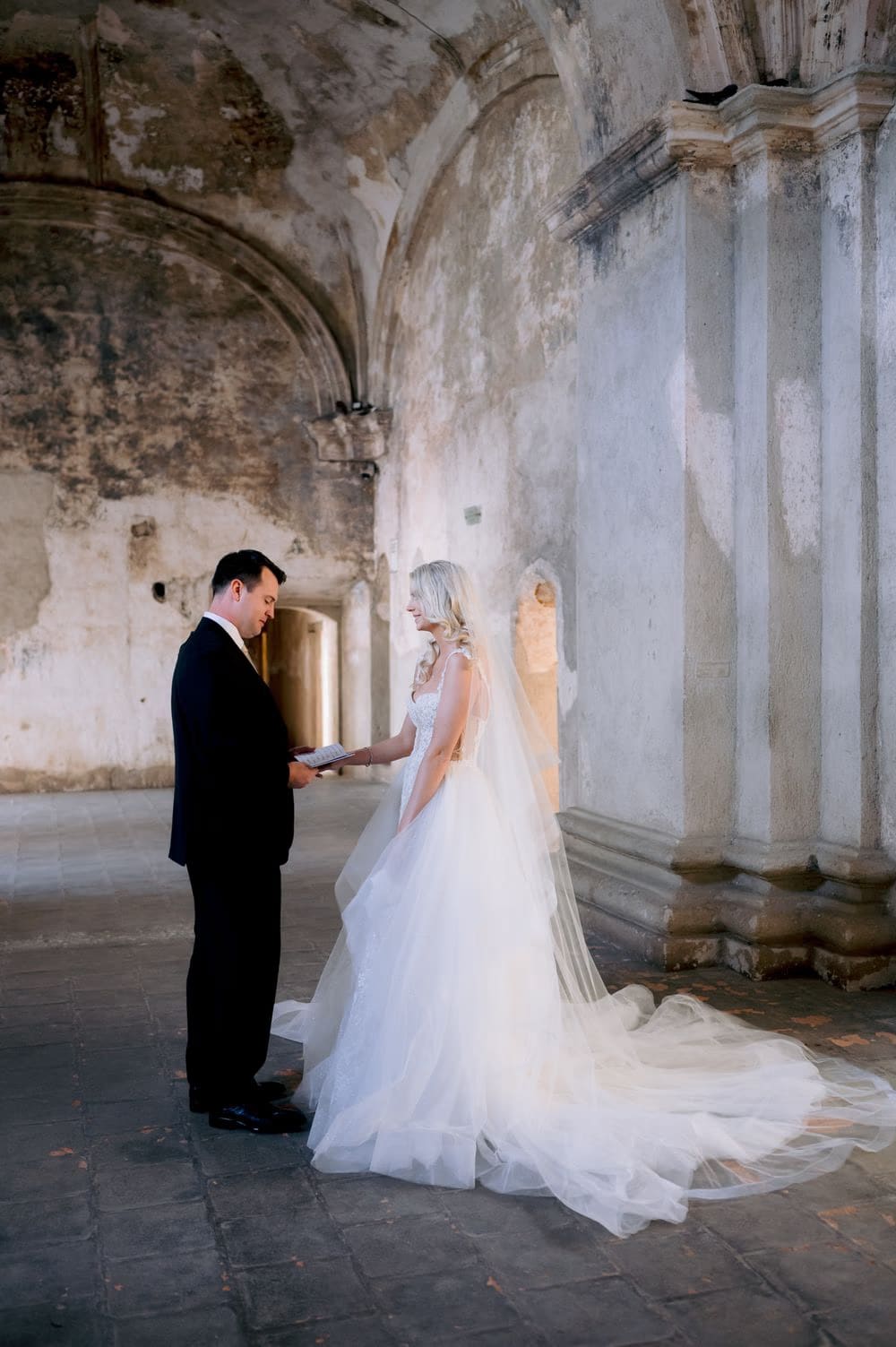 Bride reads her vows aloud beneath the soaring vault of Santa Clara — private exchange in Antigua Guatemala.