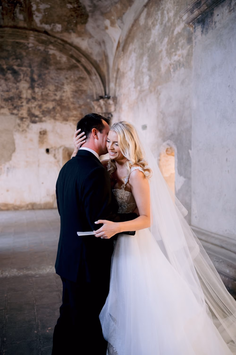 Sydney and Nathan embrace after exchanging private vows beneath the arches of Santa Clara Ruins.