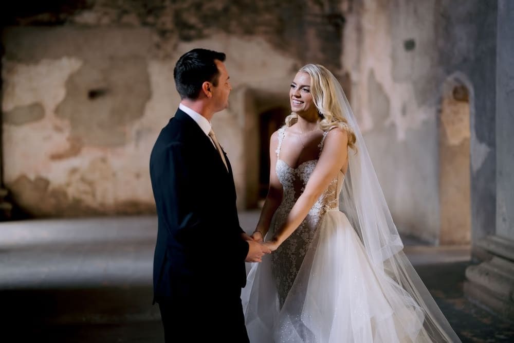 Bride and groom hold hands and laugh together inside the cloister of Santa Clara Ruins.
