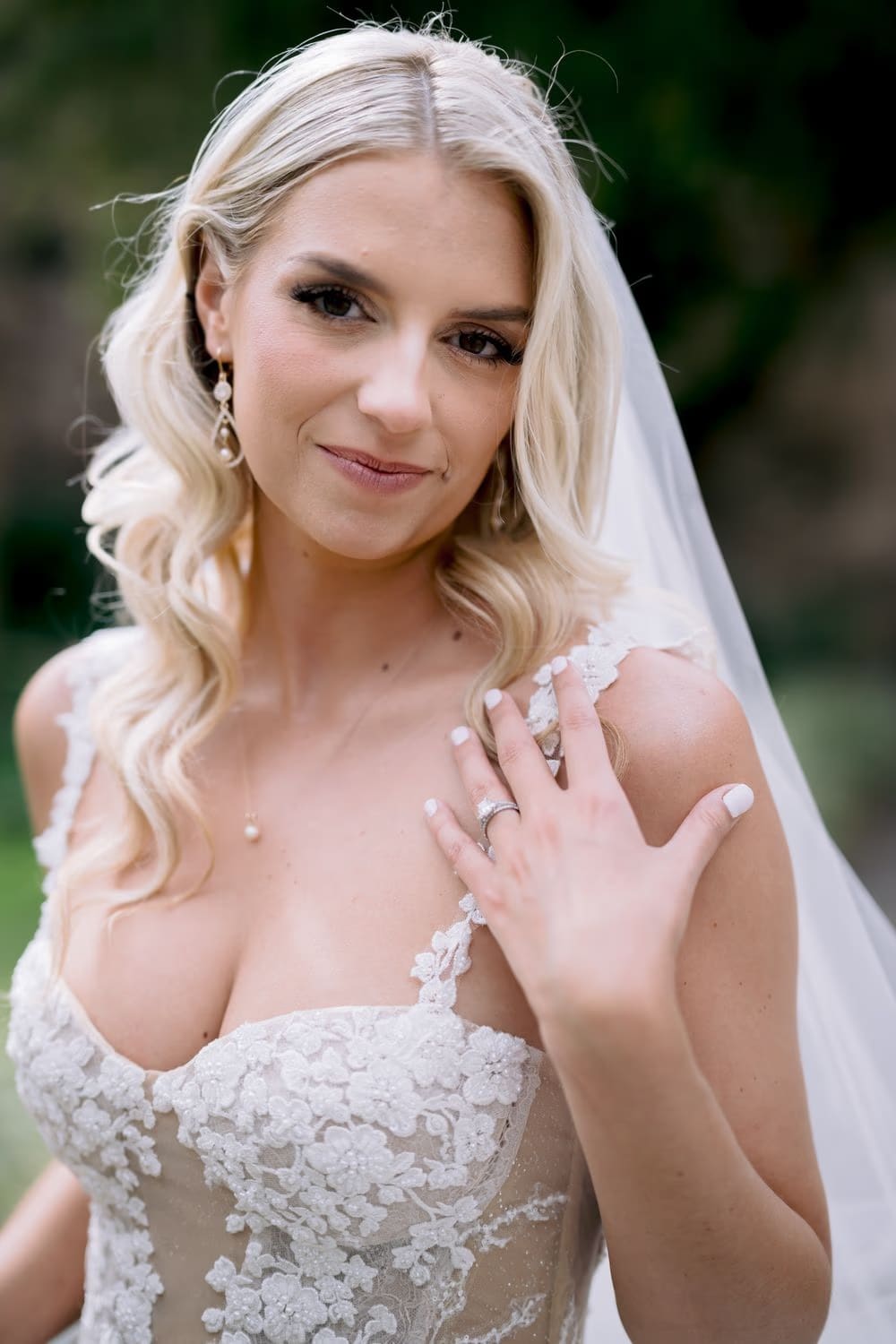 Close-up portrait of bride Sydney showing her wedding ring against soft green foliage in Antigua Guatemala.