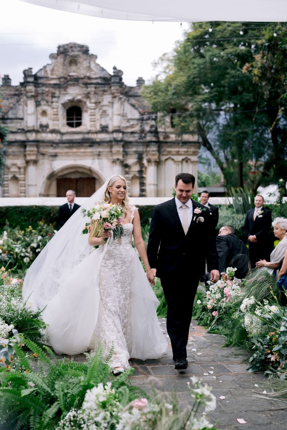 Sydney and Nathan walk back down the aisle as newlyweds after their ceremony at San José el Viejo.