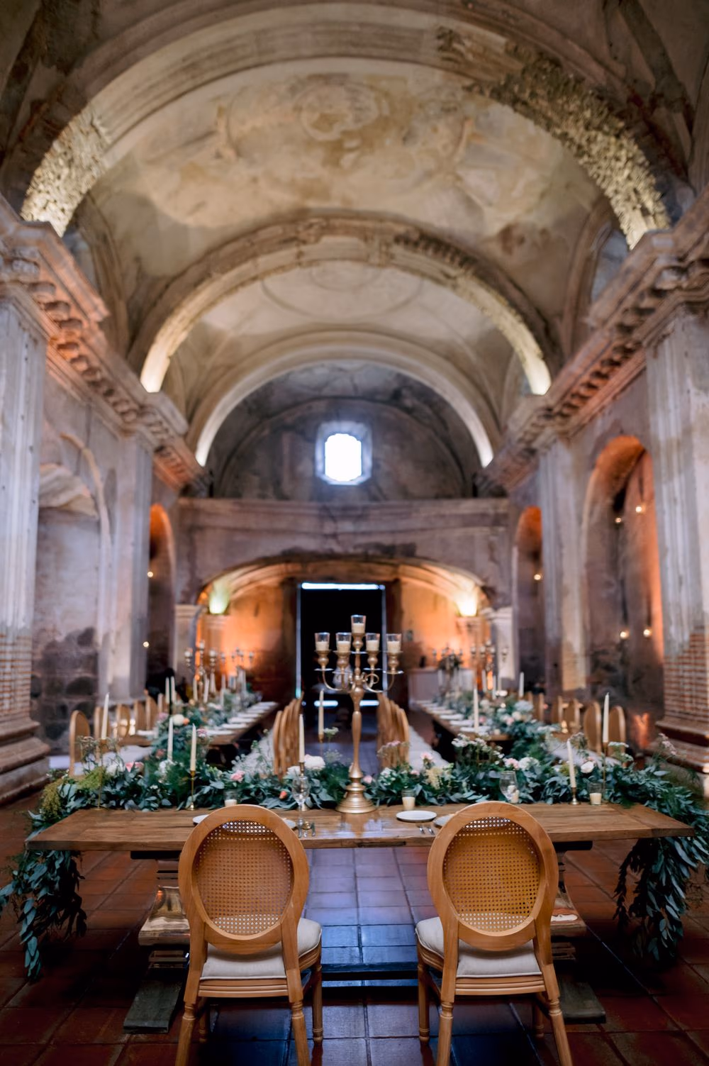 Full view of the candle-lit reception tables stretching down the nave of San José el Viejo Ruins in La Antigua.