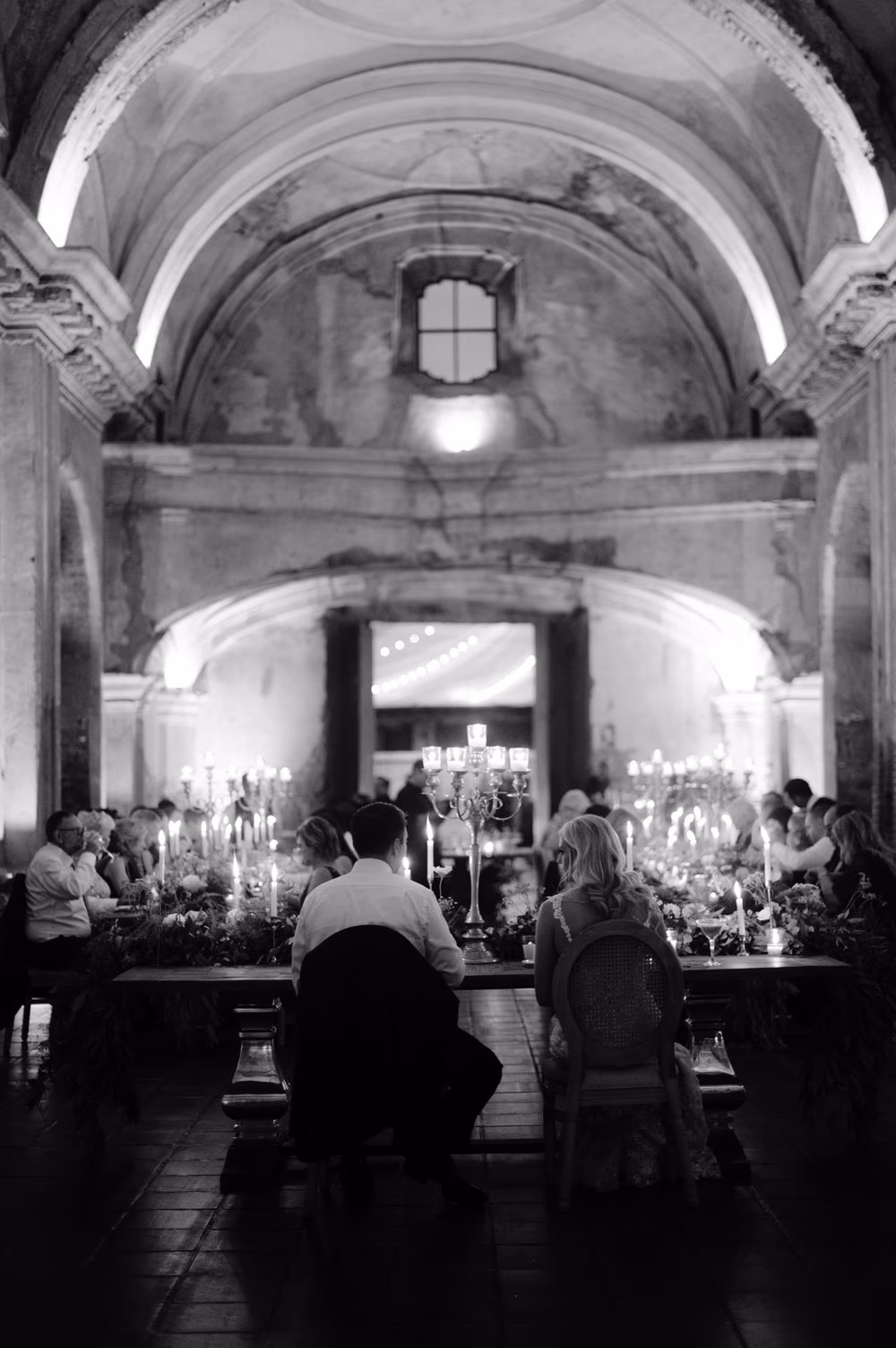 Black-and-white view from behind the head table during the candle-lit reception inside San José el Viejo Ruins.