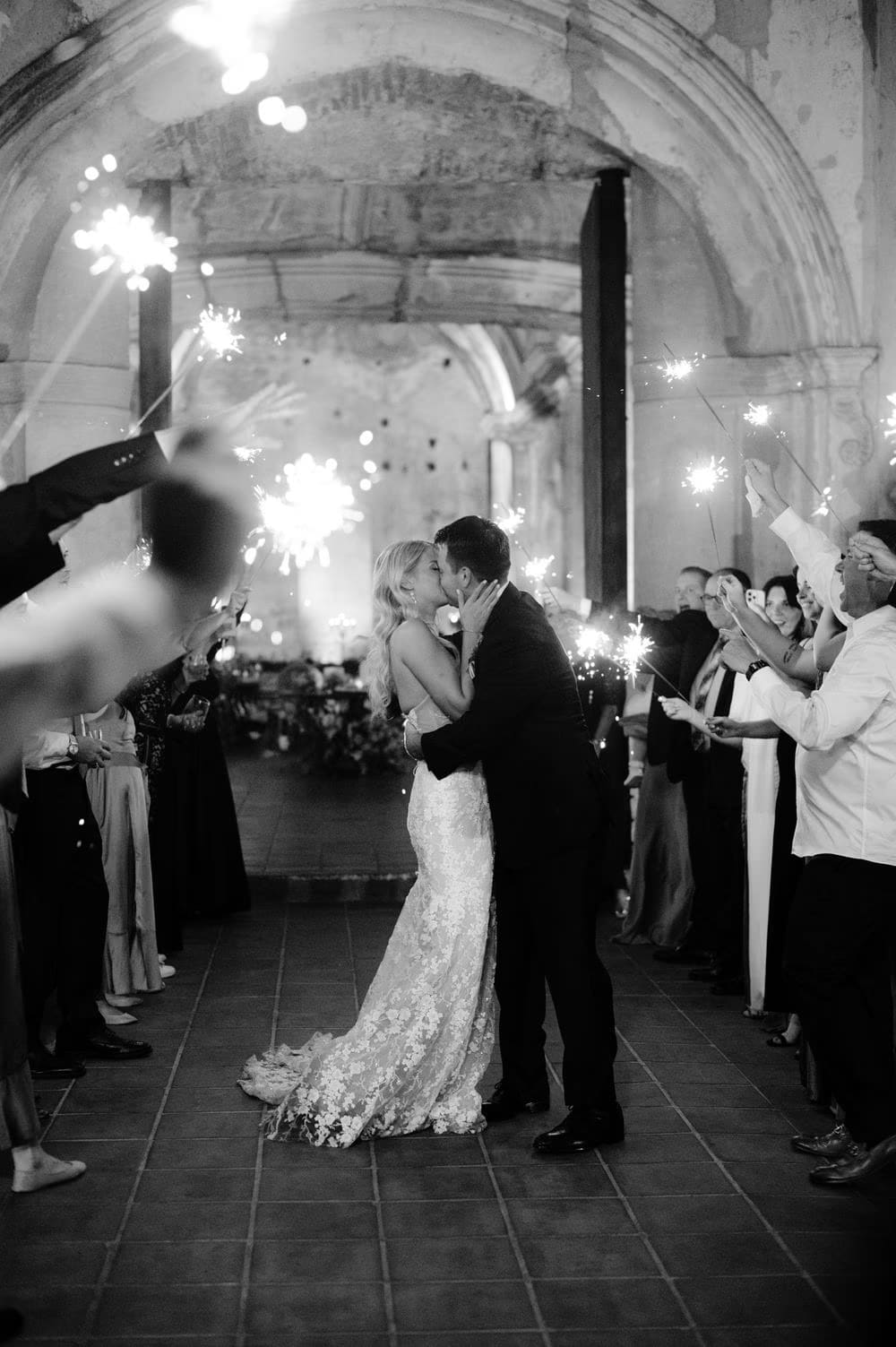 Bride and groom share a kiss during their sparkler exit at the end of the reception at San José el Viejo Ruins.