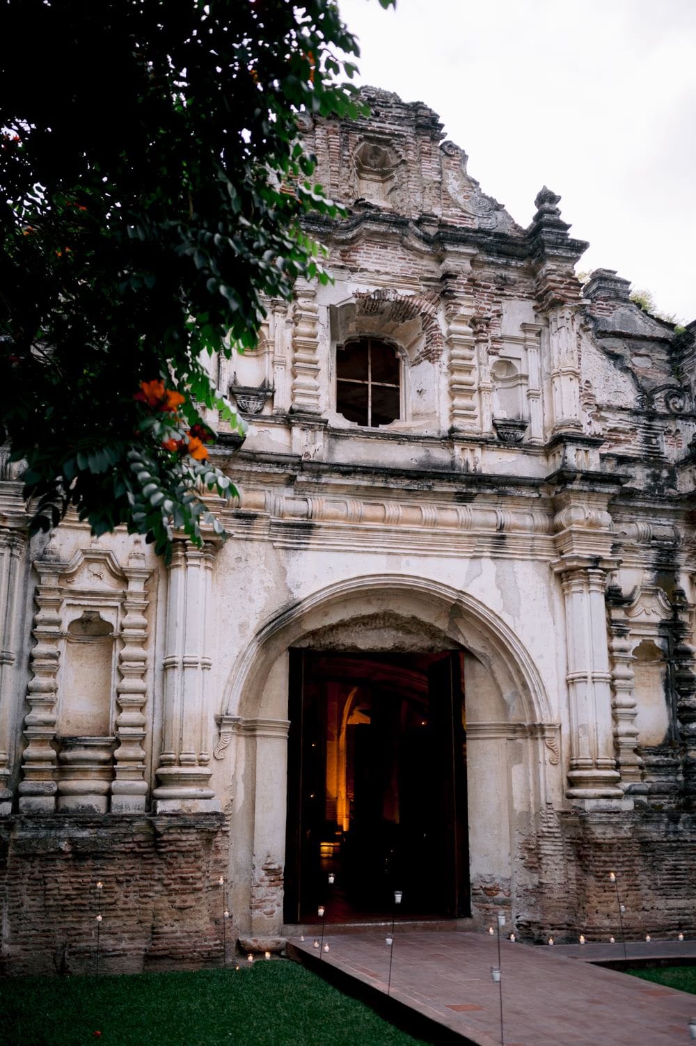 Glowing facade of San José el Viejo Ruins lit by candles at dusk on Sydney and Nathan's destination wedding night in Antigua Guatemala — editorial wedding portrait of the venue.