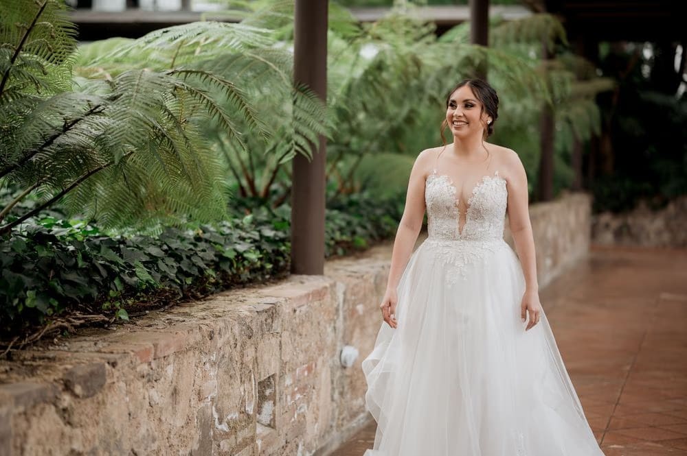 Bridal portrait beneath tropical ferns along a stone garden path at Hotel Casa Santo Domingo, Antigua Guatemala.