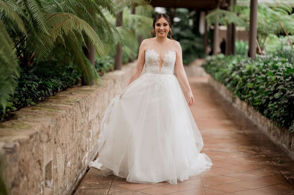 Bride walking through a fern-lined garden corridor at the colonial monastery, Antigua Guatemala.