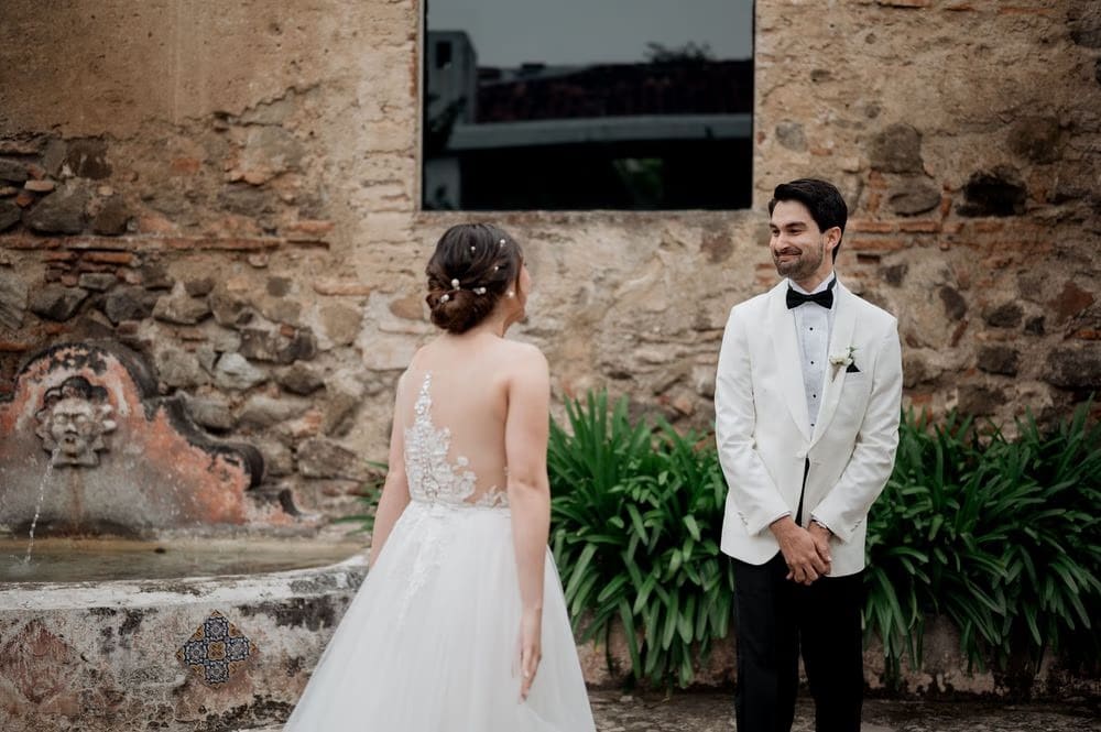Groom smiles as he sees the bride from behind during their first look at Hotel Casa Santo Domingo.