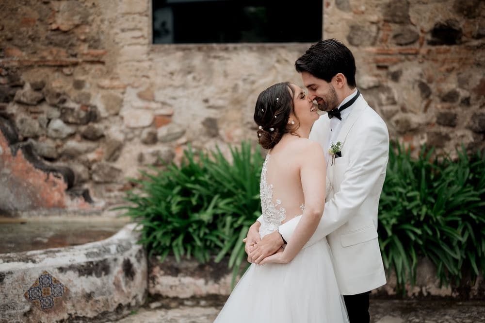 Couple about to kiss in front of an old stone fountain wall during portraits at the colonial monastery.