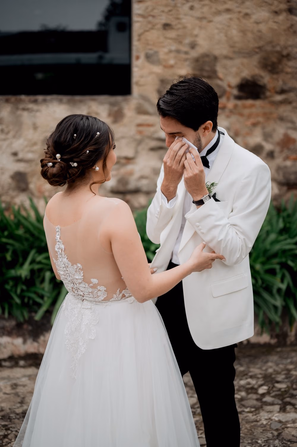 Bride gently holds the emotional groom's arm during their private first look at the colonial monastery.