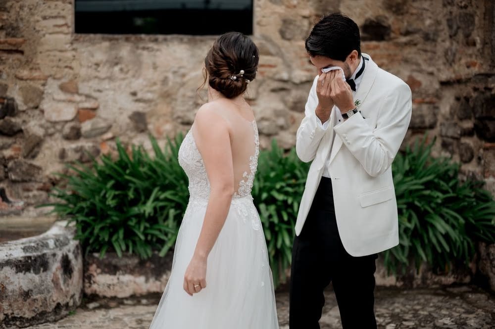 Groom dabs his eyes as the bride faces him during their first look at Casa Santo Domingo.