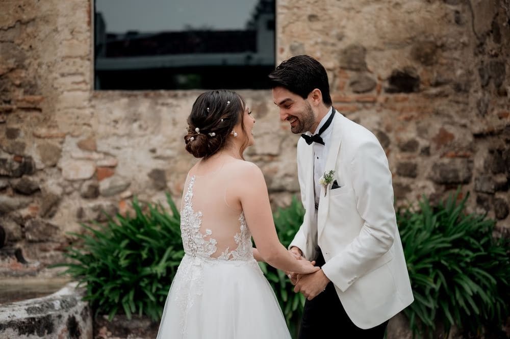 Couple laugh and clasp hands after the first look reveal in the monastery courtyard, Antigua Guatemala.