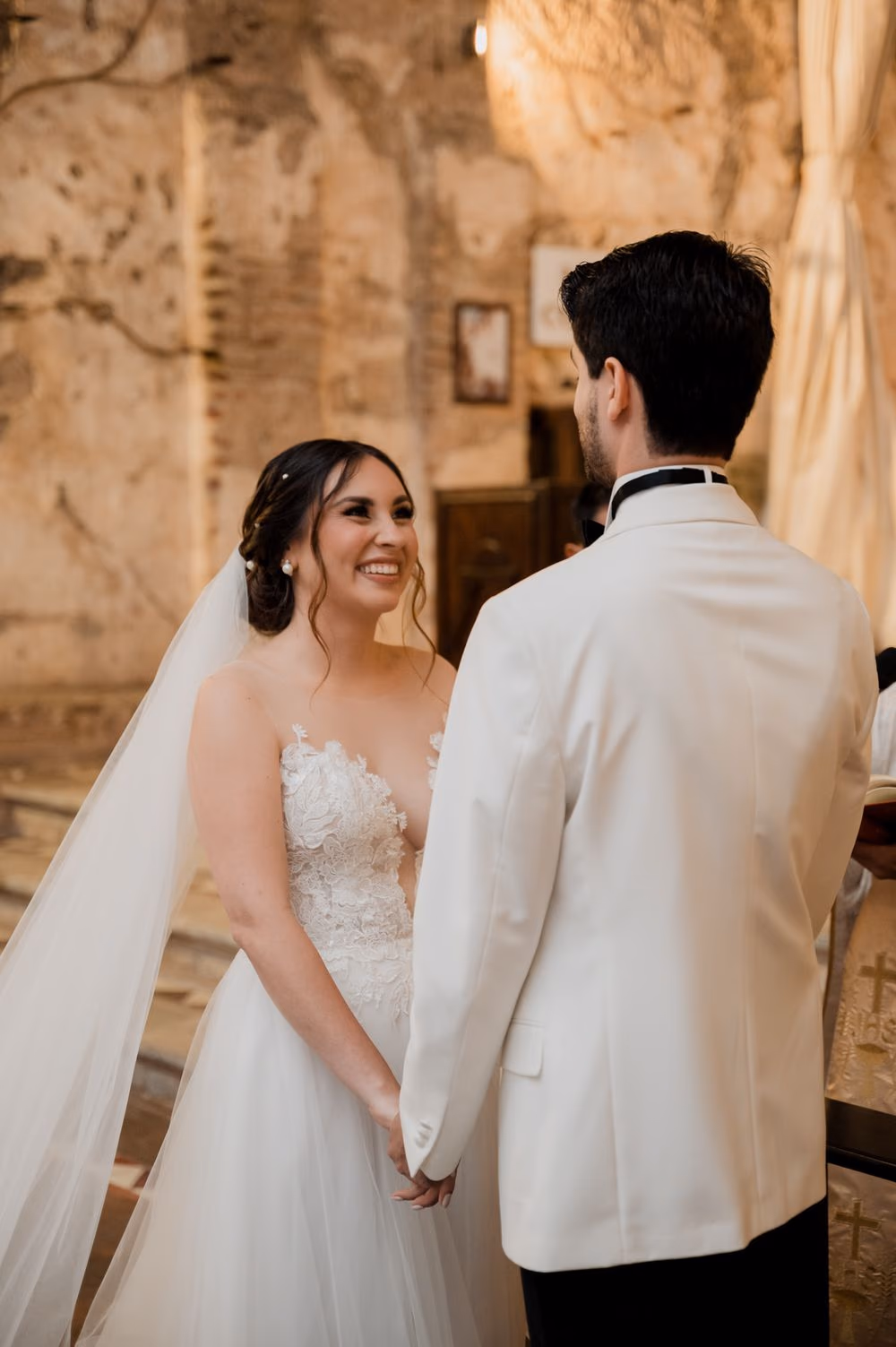 Bride smiles at her partner during their vows inside the colonial monastery church in Antigua Guatemala.