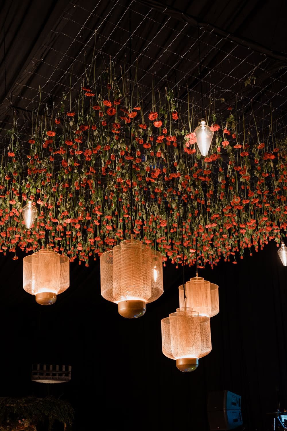 Suspended ceiling installation of red carnations and woven lanterns over the dance floor — by Addy Florales.